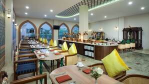 A restaurant with multiple dining tables, chairs, and a buffet area. - Alhambra Hotel & Convention, Bw Signature Collection (Singaparna)