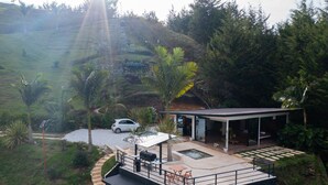 A modern house with a patio, outdoor seating, and a car parked nearby.