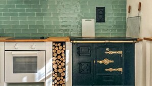 Une cuisine équipée d’une cuisinière, d’un four et d’un meuble noir avec des poignées en laiton.