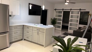 Una cocina moderna con una isla central, armarios integrados y un refrigerador grande.