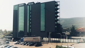A modern building with a parking lot in front.