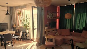 A cozy living room with a sofa, chairs, a dining table, and a coffee table.