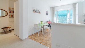 Un salon moderne comprenant un coin repas, une grande fenêtre offrant une belle vue et une bibliothèque.