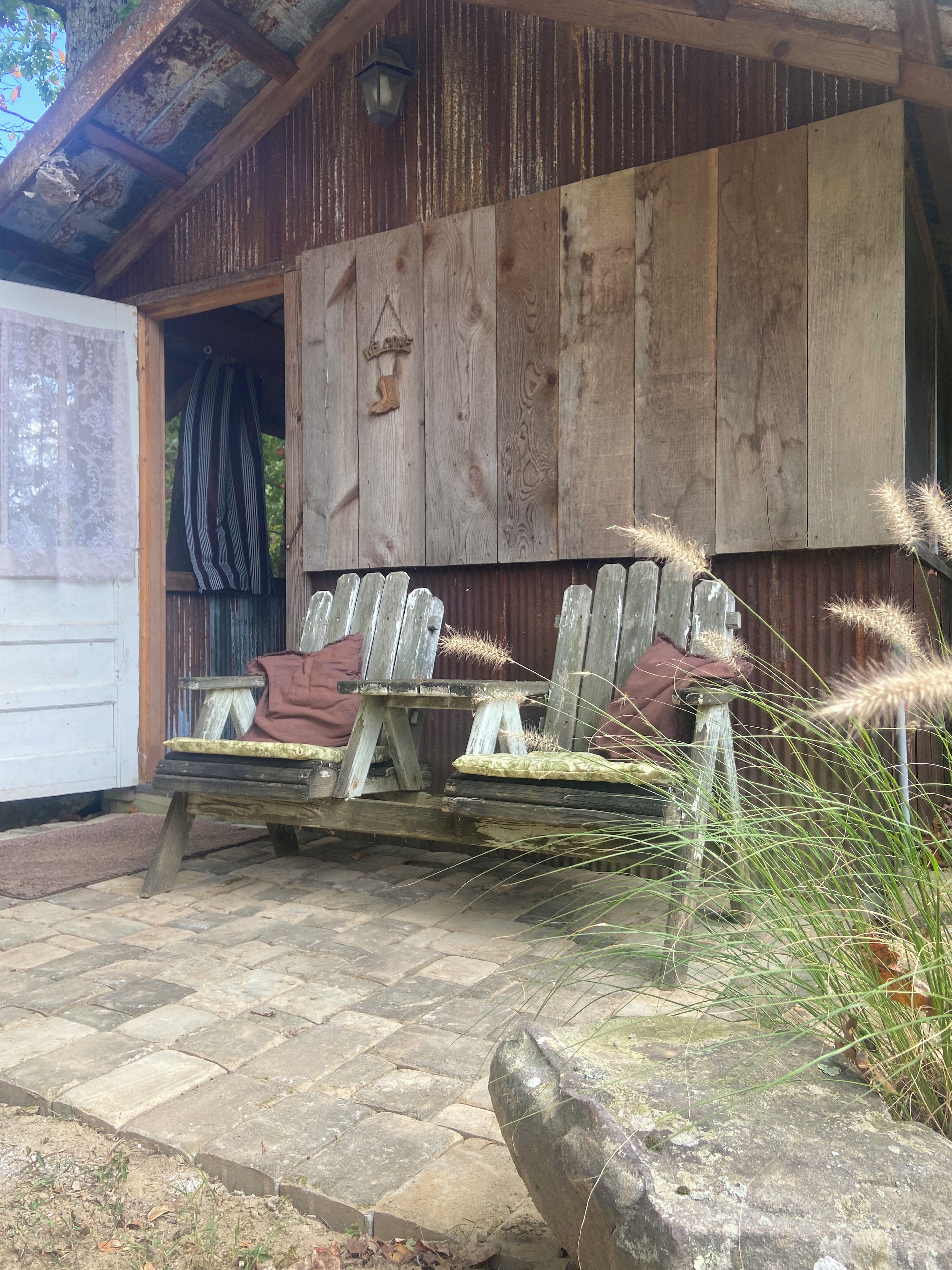A rustic wooden building with a bench and a table outside.