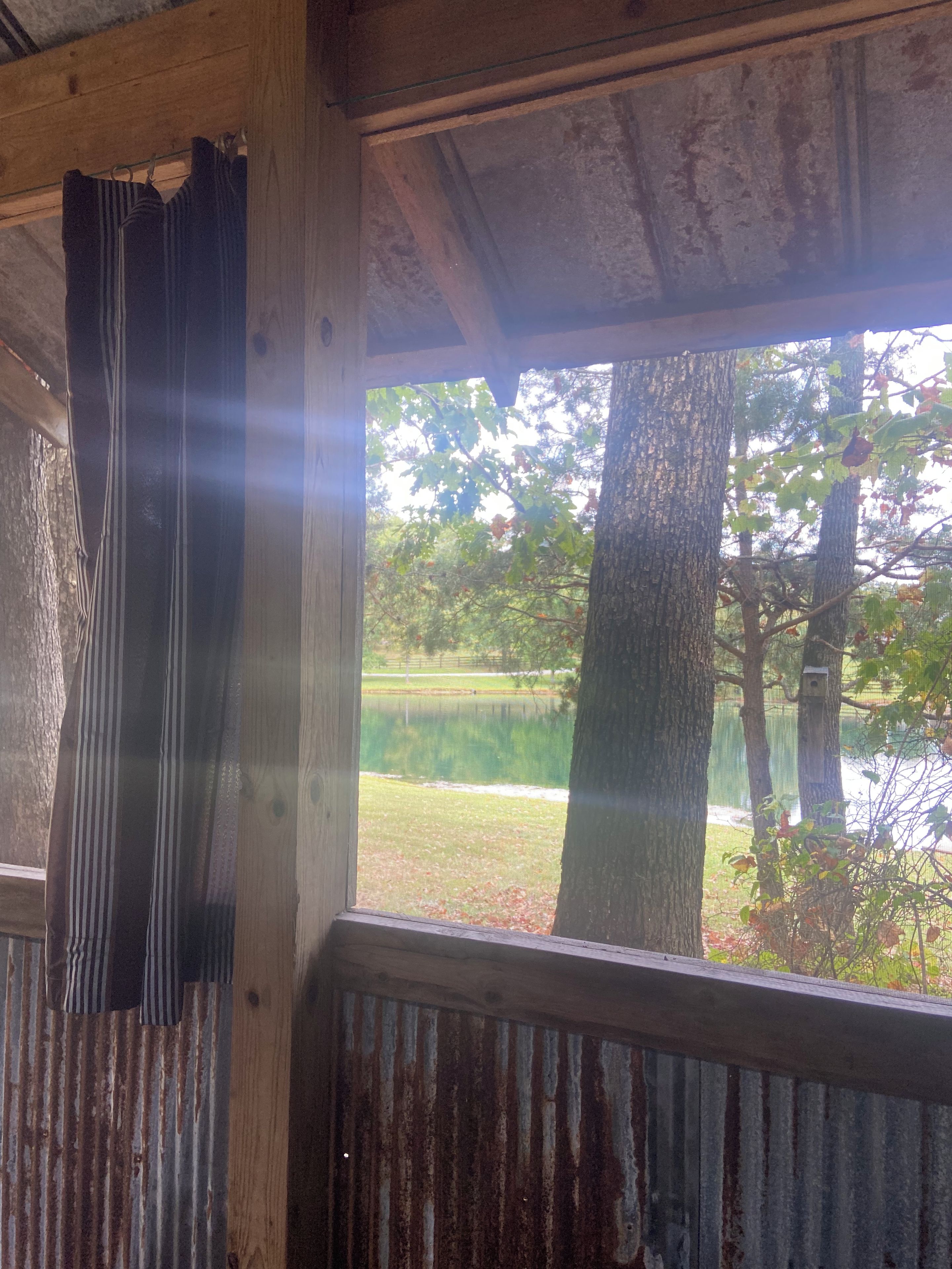A rustic wooden structure with a view of a lake and trees.
