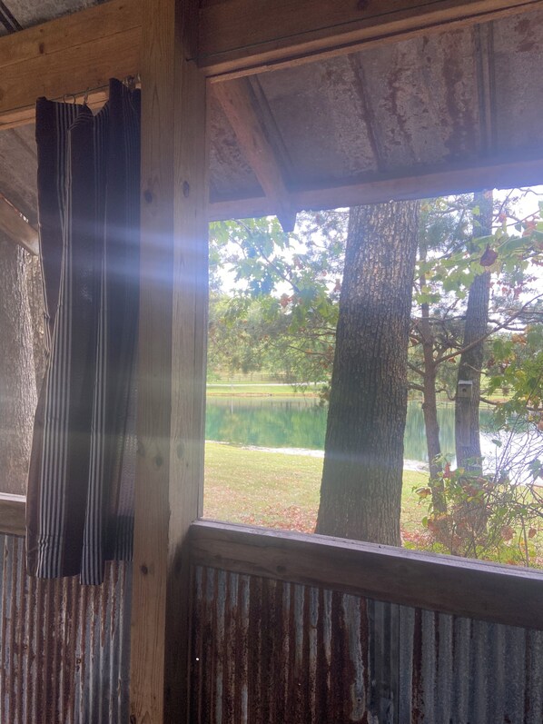 A rustic wooden structure with a view of a lake and trees.