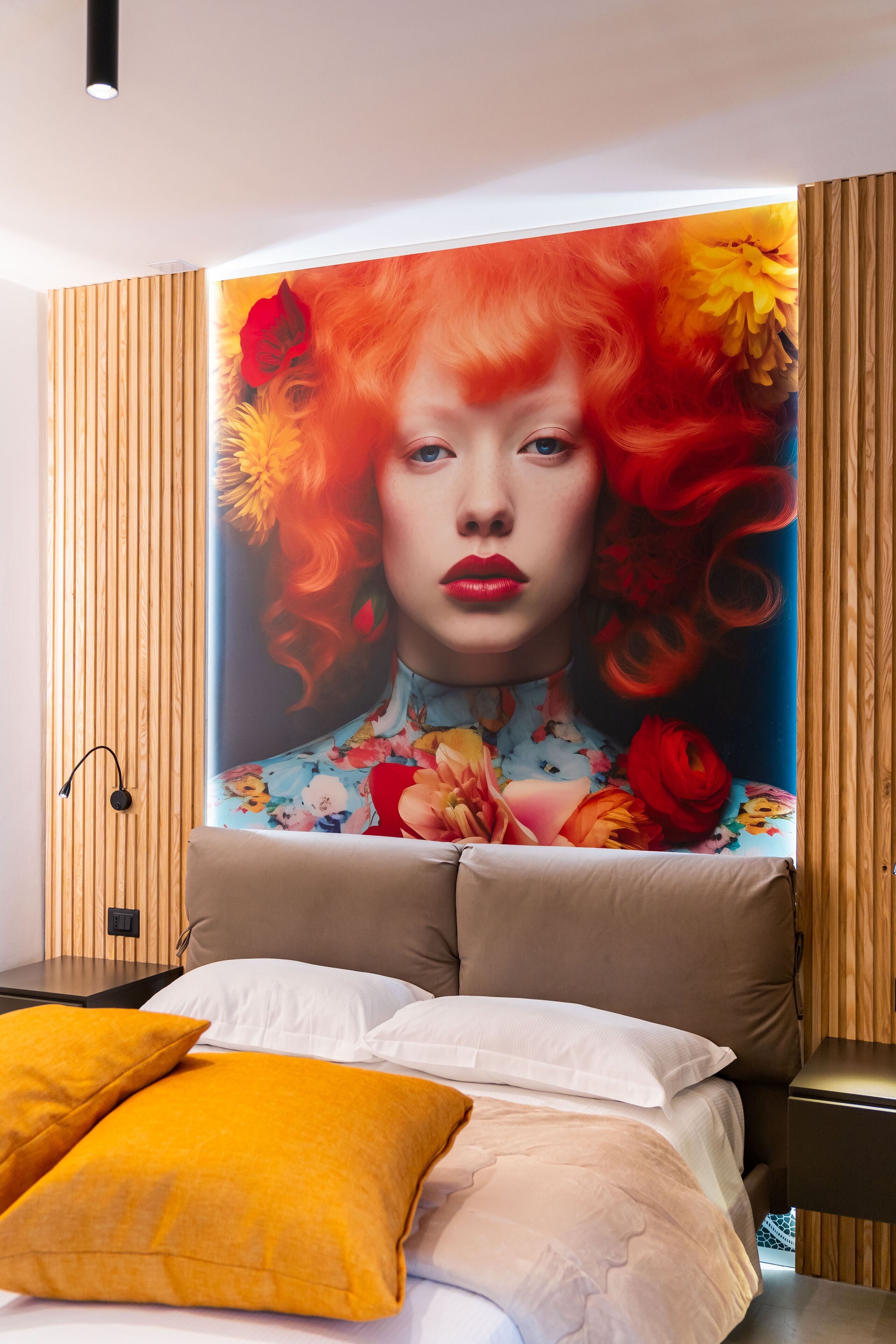 A bedroom with a large floral mural on the wall, a bed with multiple pillows, and a wooden panel design on the walls.