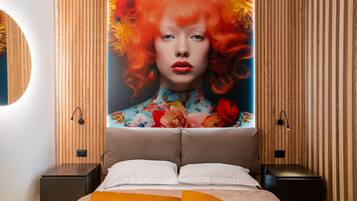 Une chambre moderne avec un grand lit, deux tables de chevet et un luminaire fixé au mur.