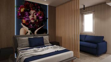 A modern bedroom with a large bed, a blue sofa, and a wall-mounted artwork.