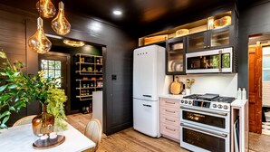 A modern kitchen with a white refrigerator, double ovens, and a microwave. - Best Location in Downtown NB Golf Cart Included! (New Braunfels)