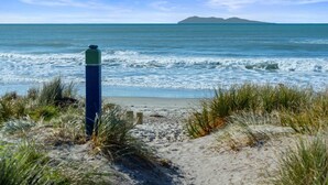 Une plage offrant une vue dégagée sur l’océan et sur une île située au loin.