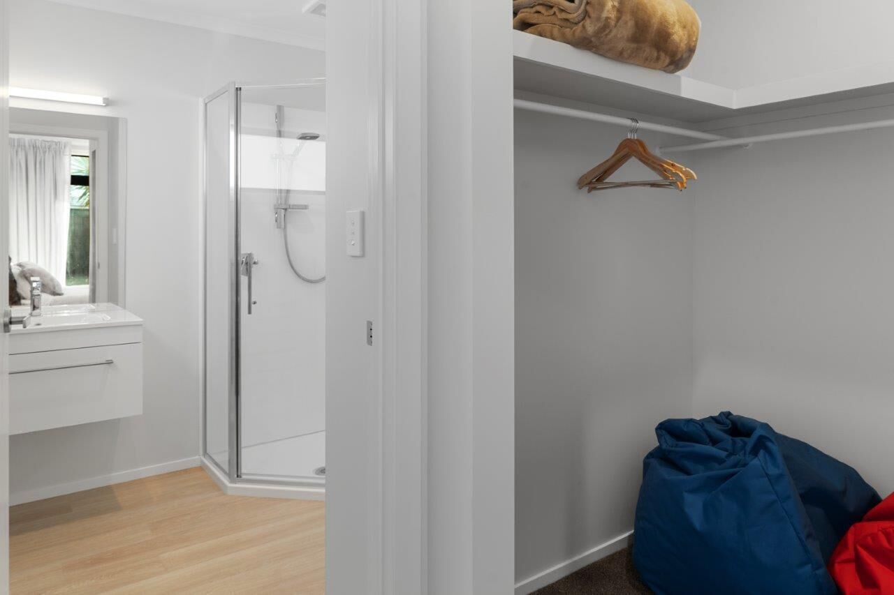 A bathroom with a shower, a mirror, and a sink.