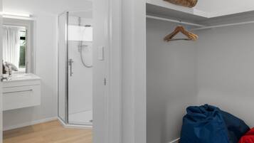 A bathroom with a shower, a mirror, and a sink.