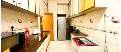 Køleskab, mikrobølgeovn, køkkentøj/tallerkener/redskaber, spisebord