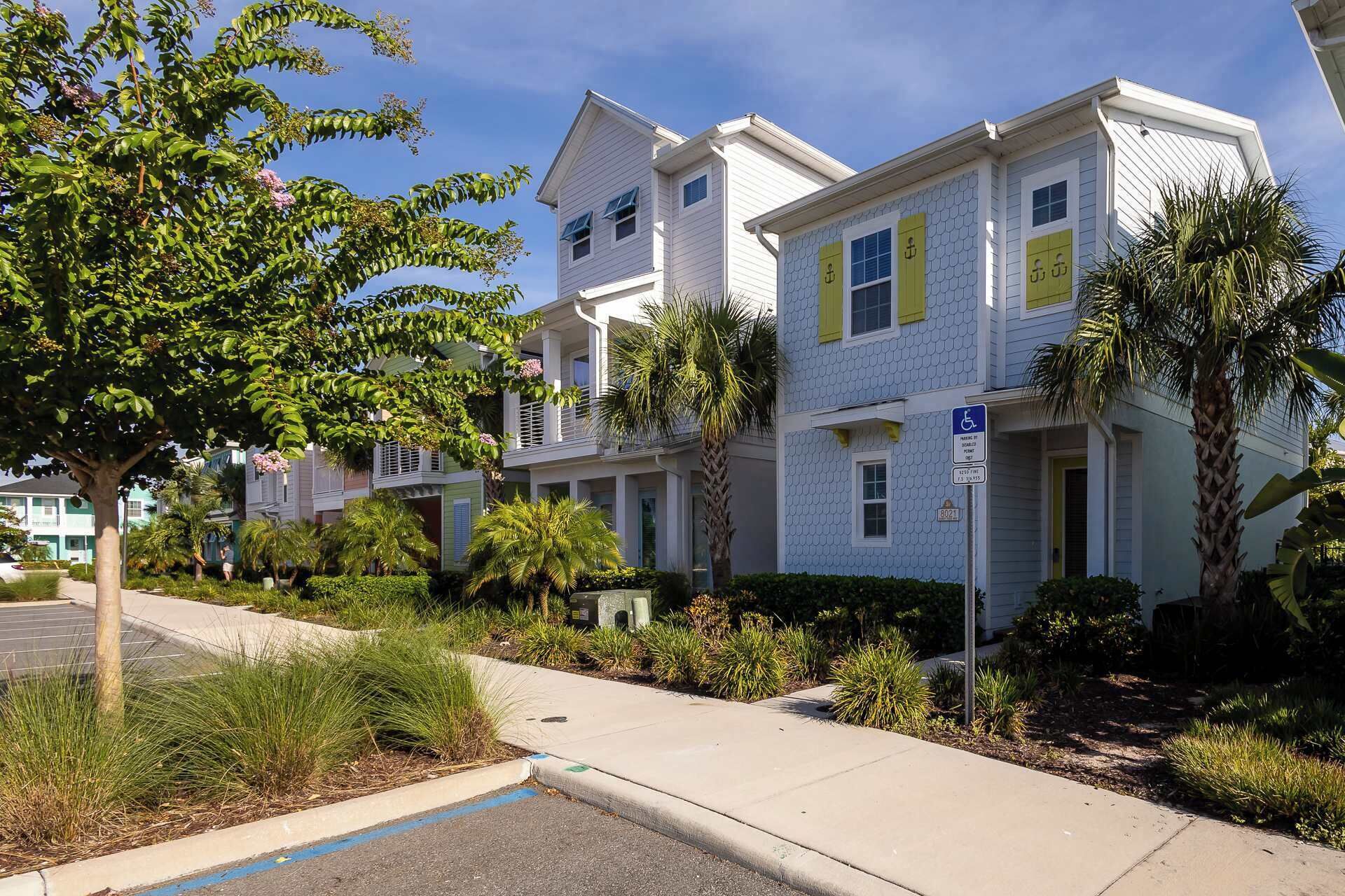 A residential building with a two-story structure, a wheelchair-accessible entrance, and a parking area with a blue line marking.