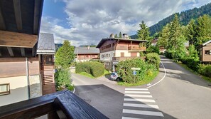 Eine Wohnstraße mit Häusern, einem Fußgängerüberweg und einem Auto, das am Straßenrand geparkt ist.