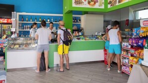 Ein farbenfroher Food-Court mit einem Coca-Cola-Kühlschrank, verschiedenen Speisen und einer Snackauslage.