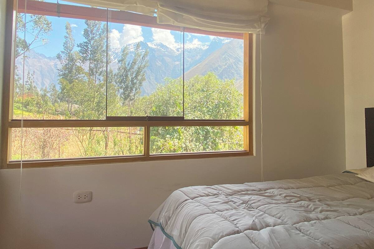 Une chambre avec une grande fenêtre donnant sur les montagnes.