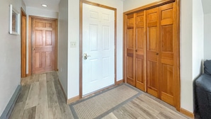 A hallway with wooden doors, a doormat, and a light fixture on the ceiling. - High View at Short Sands - Beautiful condo at Short Sands Beach (York)