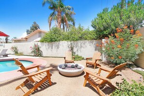 A backyard with a pool, wooden chairs, and a fire pit. - Fully furnished turnkey home located in gated Bermuda Dunes Country Club. (Bermuda Dunes)