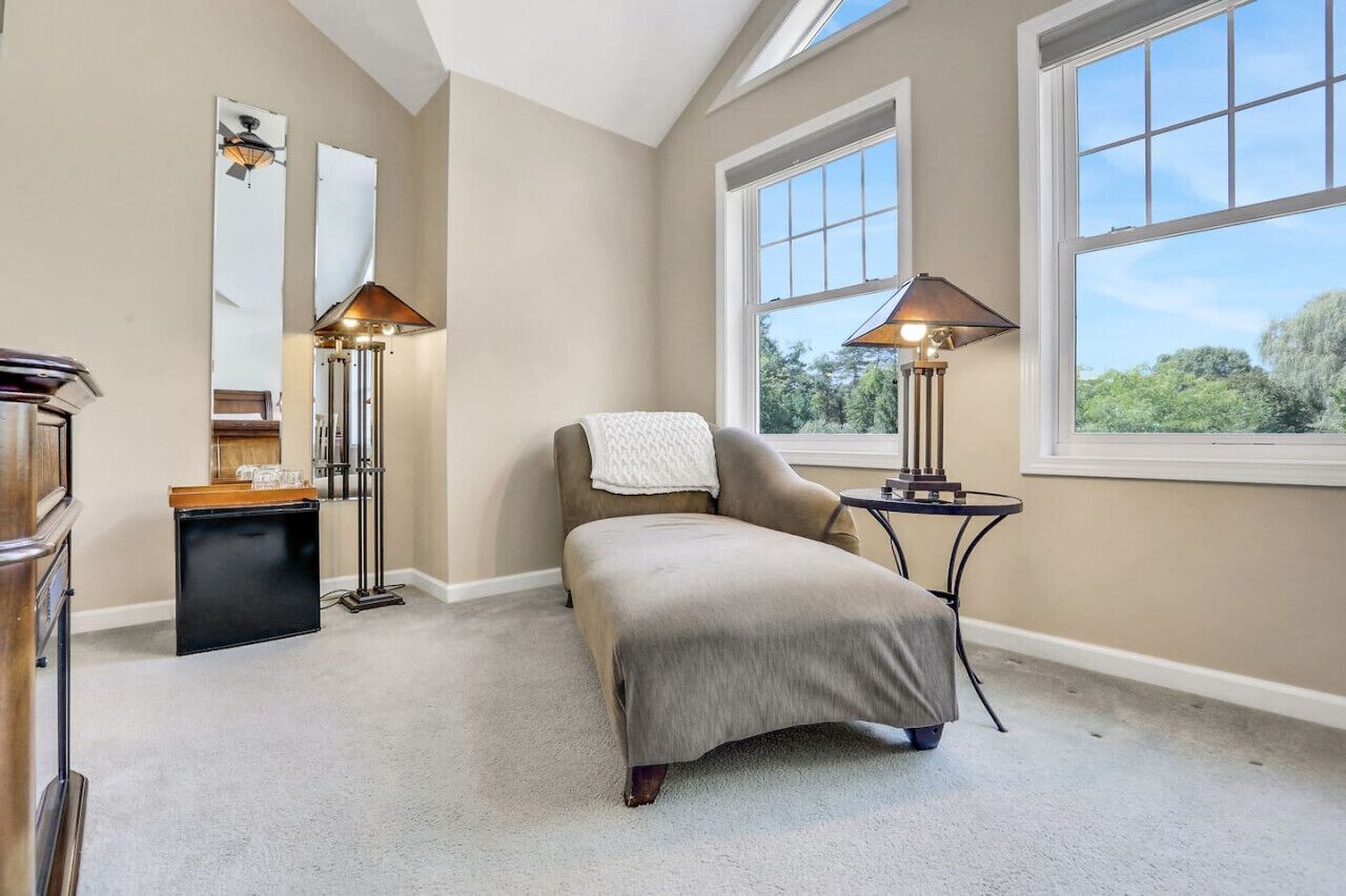 A room with a bed, a desk, a chair, a lamp, and a window.