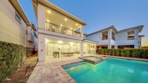 A modern two-story house with a swimming pool, outdoor furniture, and a well-maintained garden. - 5BR, Reunion Resort, villa, games room (Kissimmee)