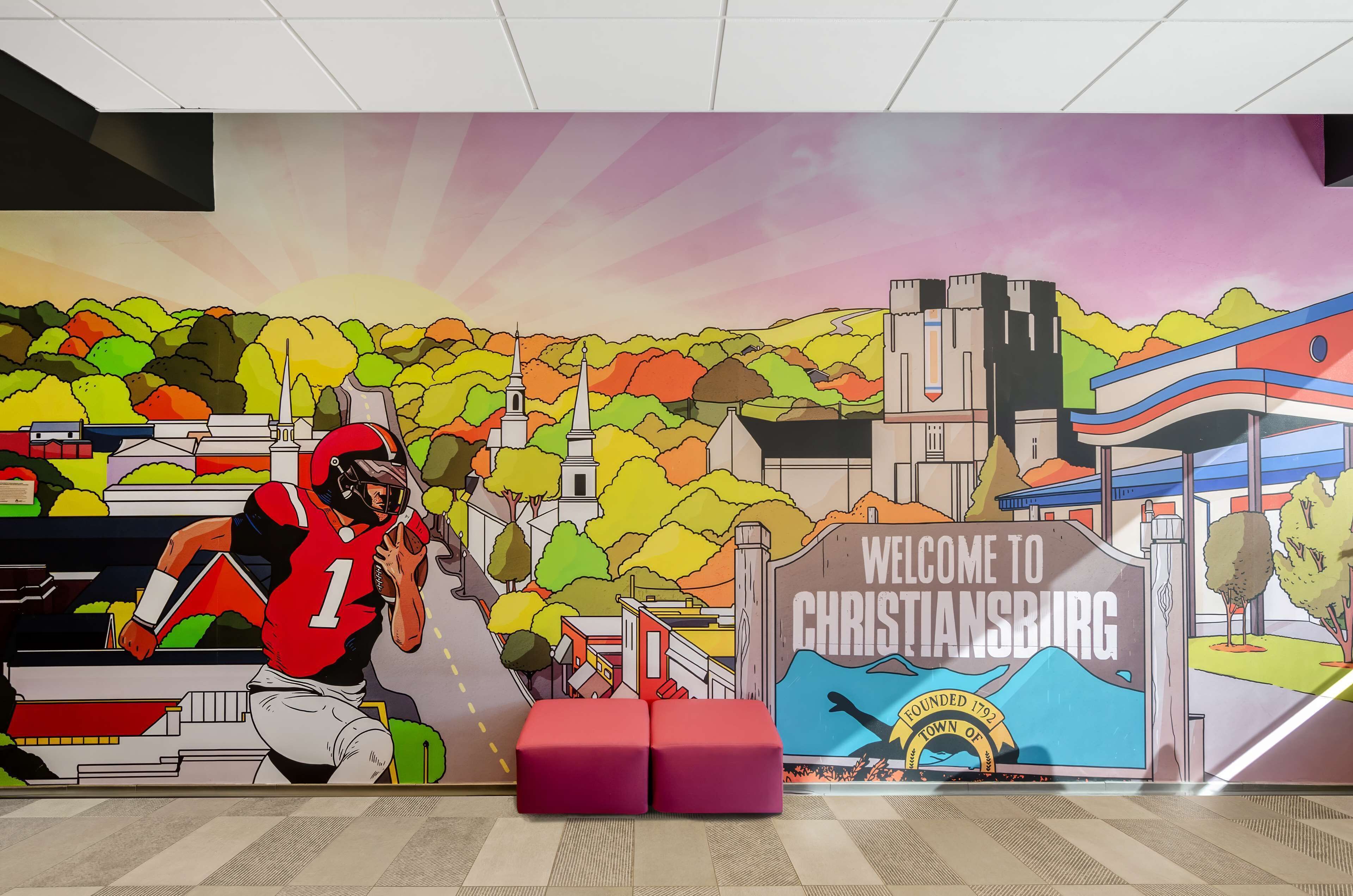 Um mural com um jogador de futebol e uma placa de boas-vindas a Christiansburg.