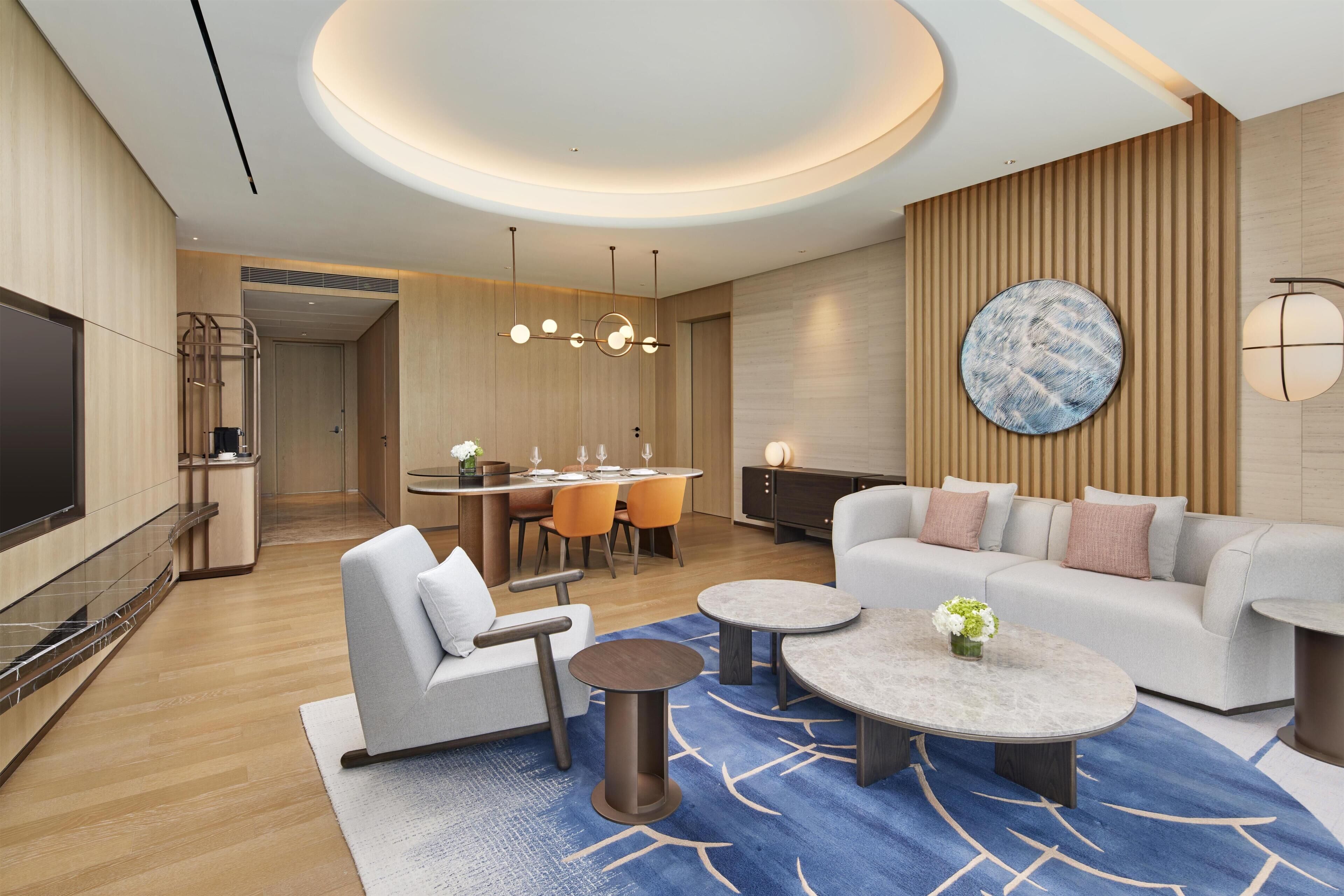 A modern living room with a sofa, coffee table, and dining area.
