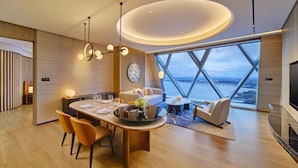 Een moderne eetruimte met een ronde tafel, stoelen en uitzicht door grote ramen.