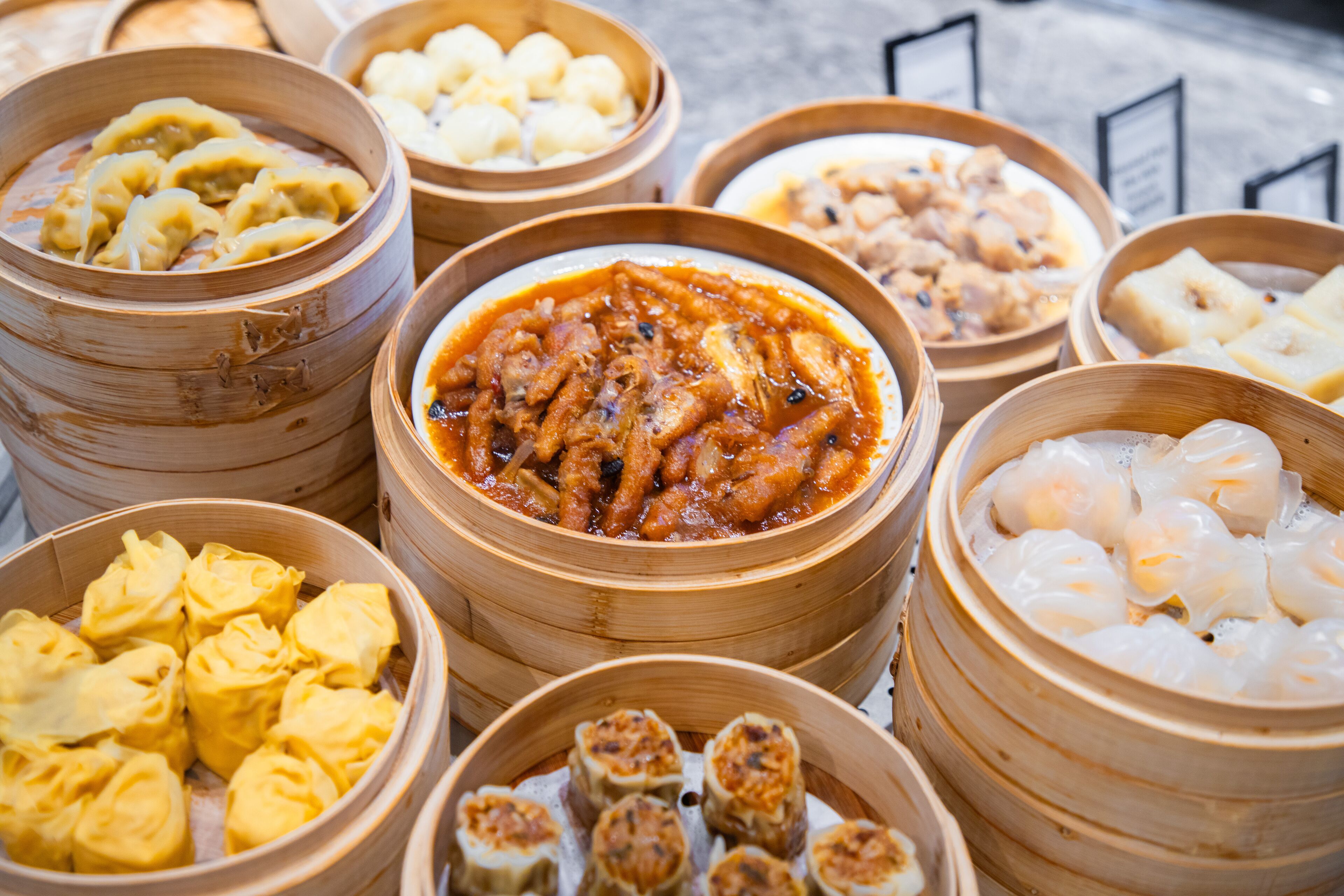 A variety of food items in bamboo steamers, including dumplings and other dishes.