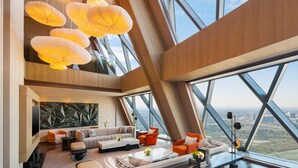Een ruime woonkamer met een modern design, voorzien van een groot raam, een zithoek en een salontafel.