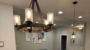 Une cuisine moderne avec un îlot central, un coin repas doté d’une table en bois et un salon avec un canapé bleu.