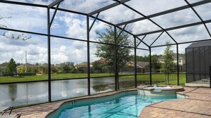 An indoor swimming pool with clear views of the surrounding neighborhood, including houses and a body of water. - Amazing Dream Family Sleep21 Privatepool Veranda (Kissimmee)