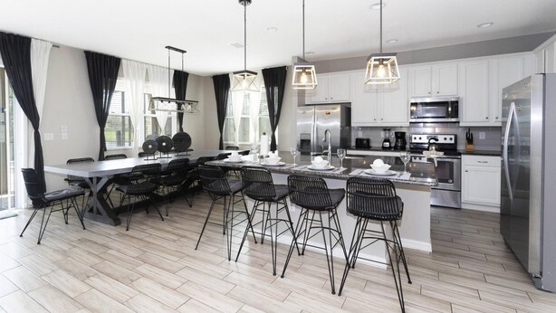 A modern kitchen with a central island, bar stools, stainless steel appliances, and pendant lighting. - Amazing Dream Family Sleep21 Privatepool Veranda (Kissimmee)