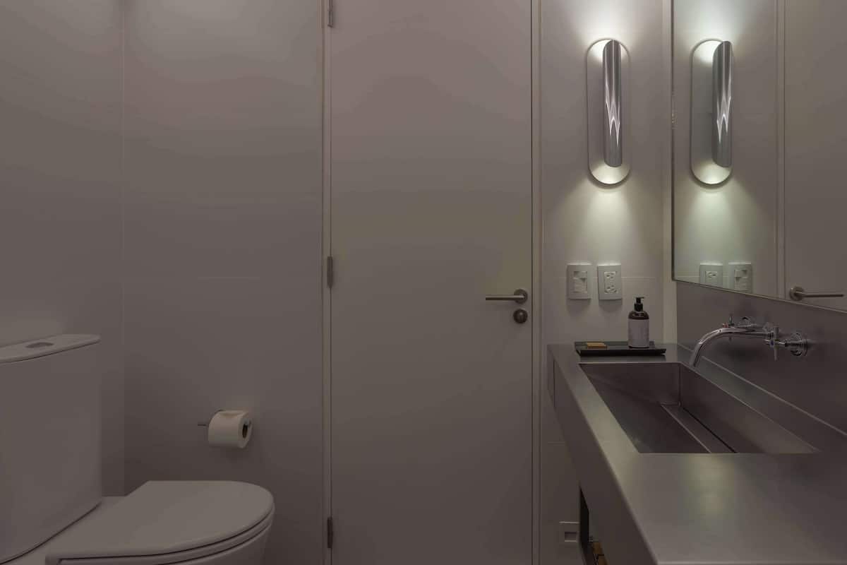 Ein modernes Badezimmer mit Toilette, Waschbecken und Spiegel.