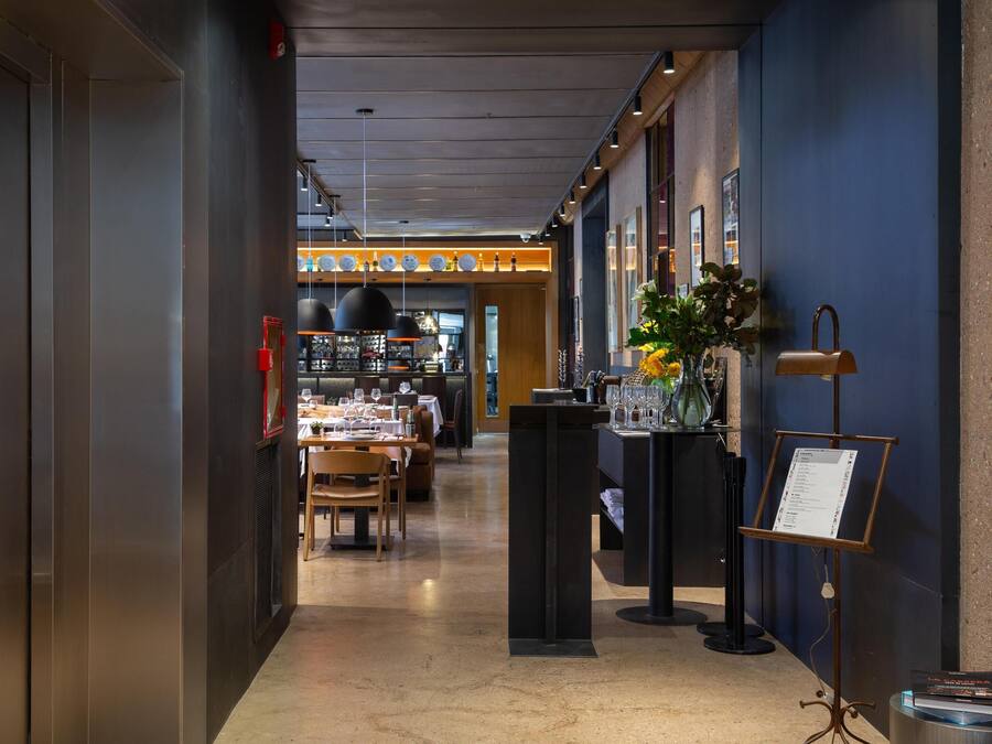 Ein Hotelgang mit Essbereich, einer Rezeption und einem Empfangsbereich mit einer Speisekarte.