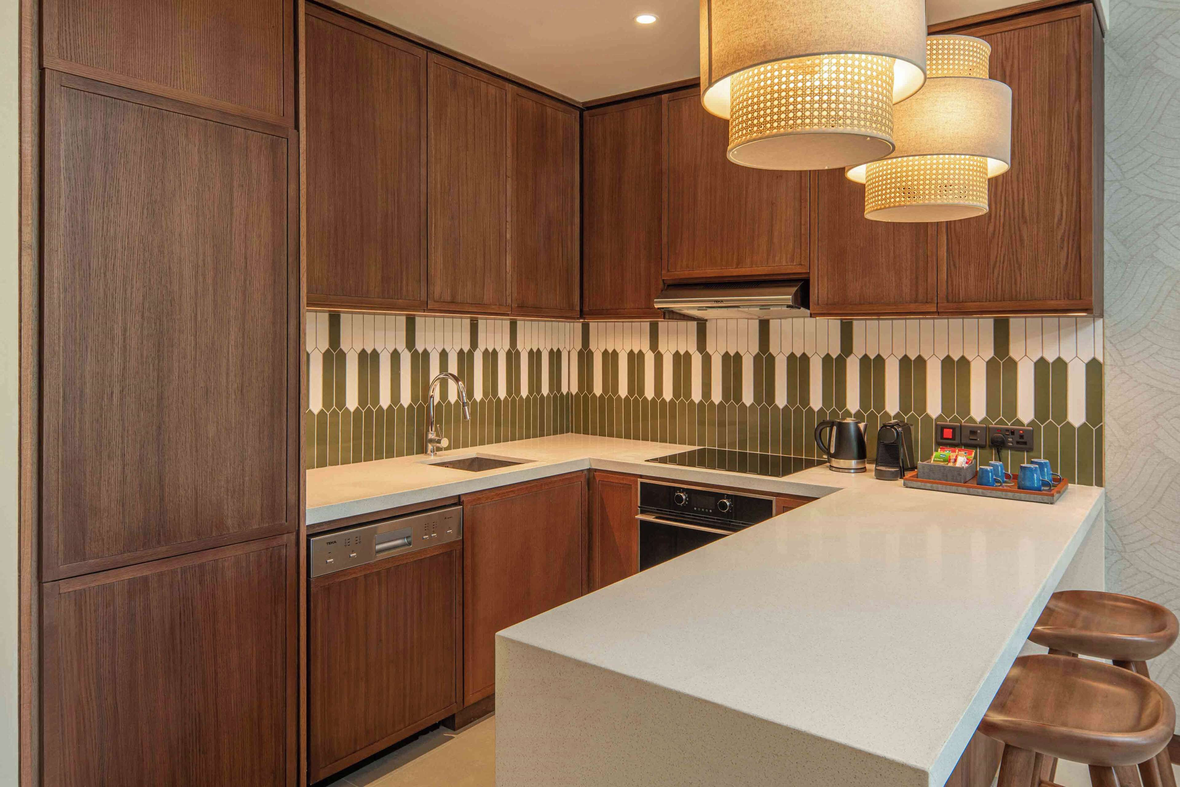 A modern kitchen with wooden cabinets, a white countertop, and a built-in oven.