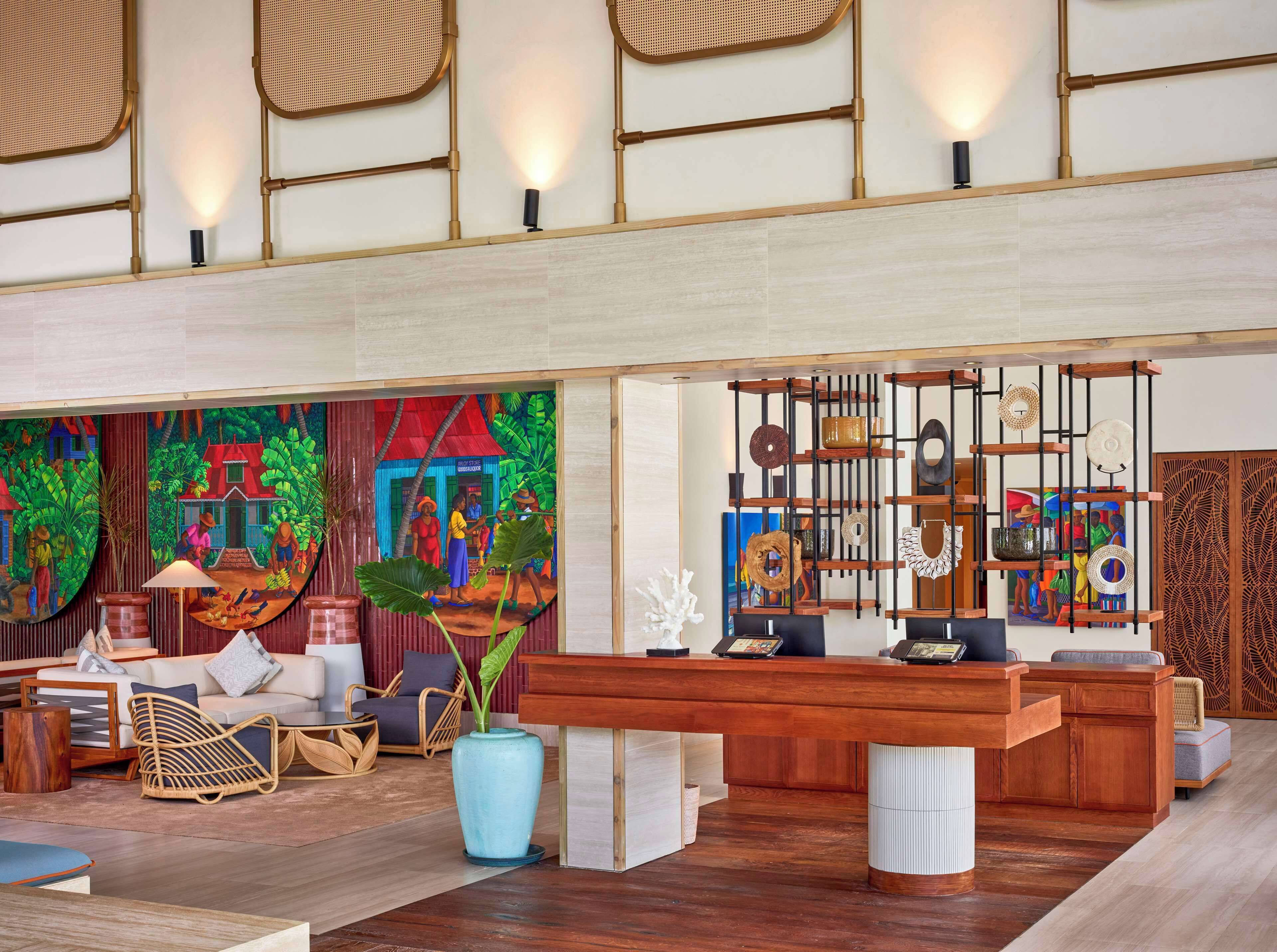 A spacious lobby with a large reception desk, comfortable seating, and a vibrant mural.