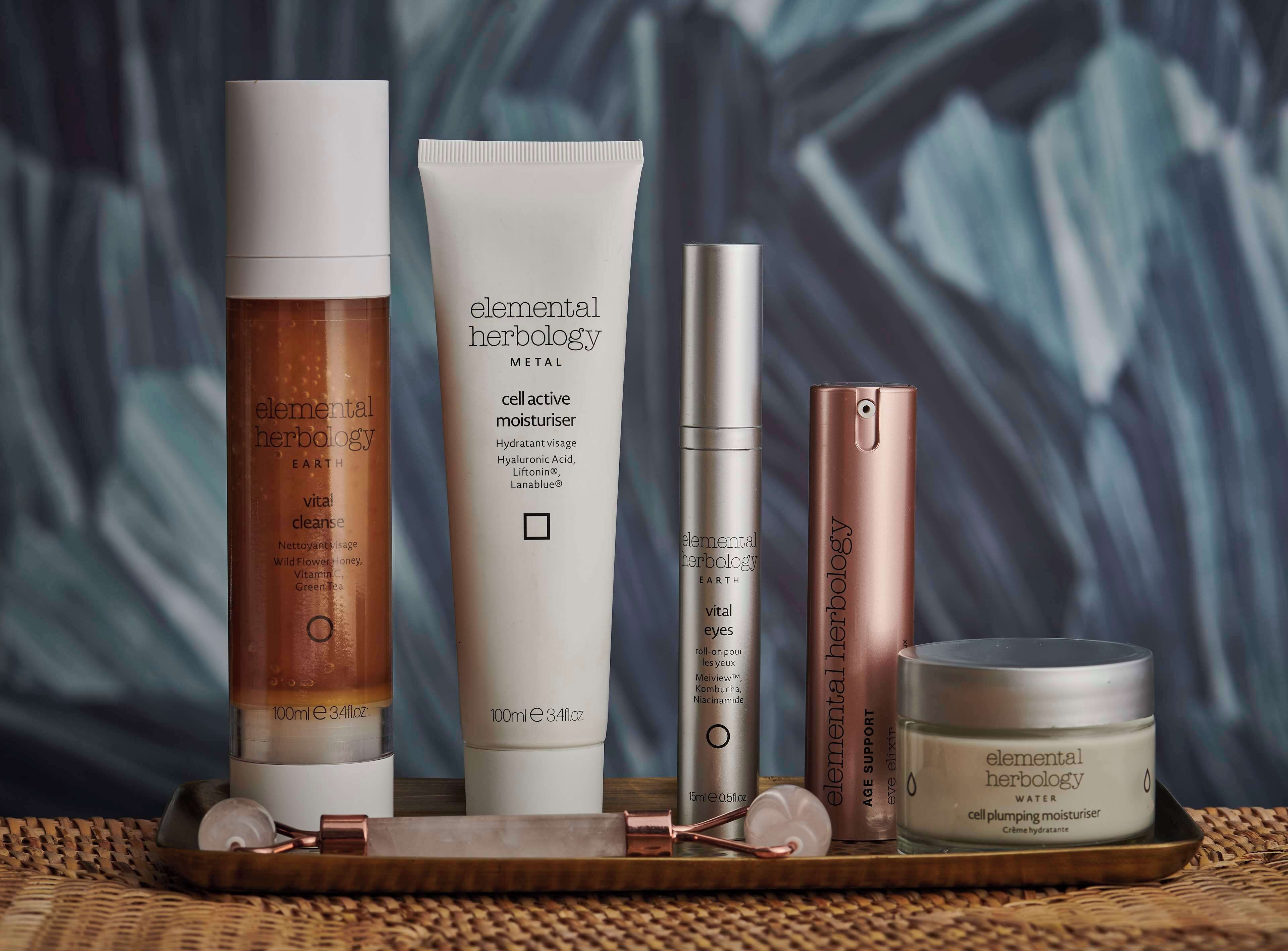 Un présentoir de produits de soins pour la peau, avec divers articles, notamment un tube de crème hydratante à action cellulaire, un applicateur roll-on pour le contour des yeux et un pot de crème hydratante repulpante.