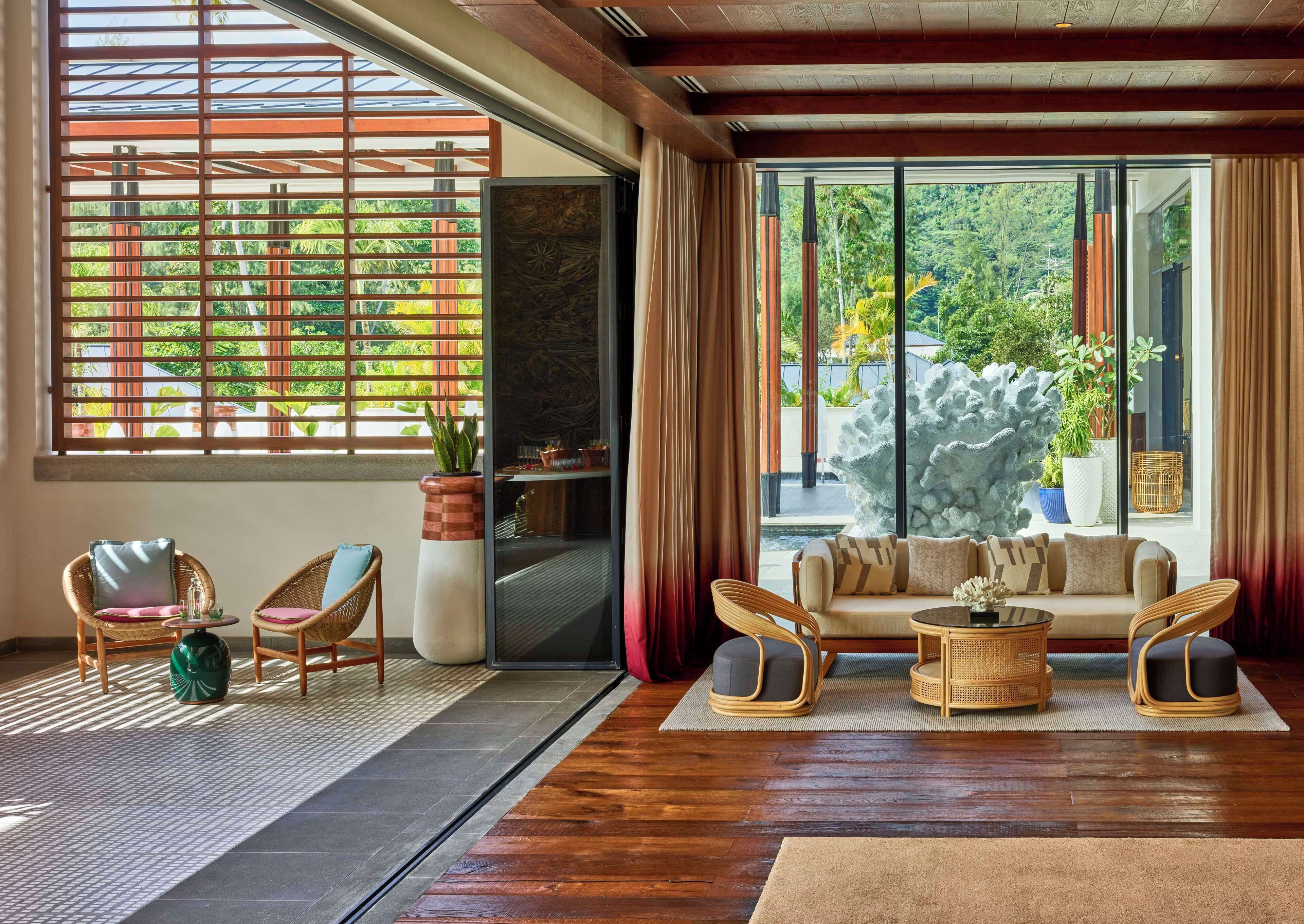 Un espacio habitable amplio con un ventanal grande, suelo de madera y un conjunto de sofás.