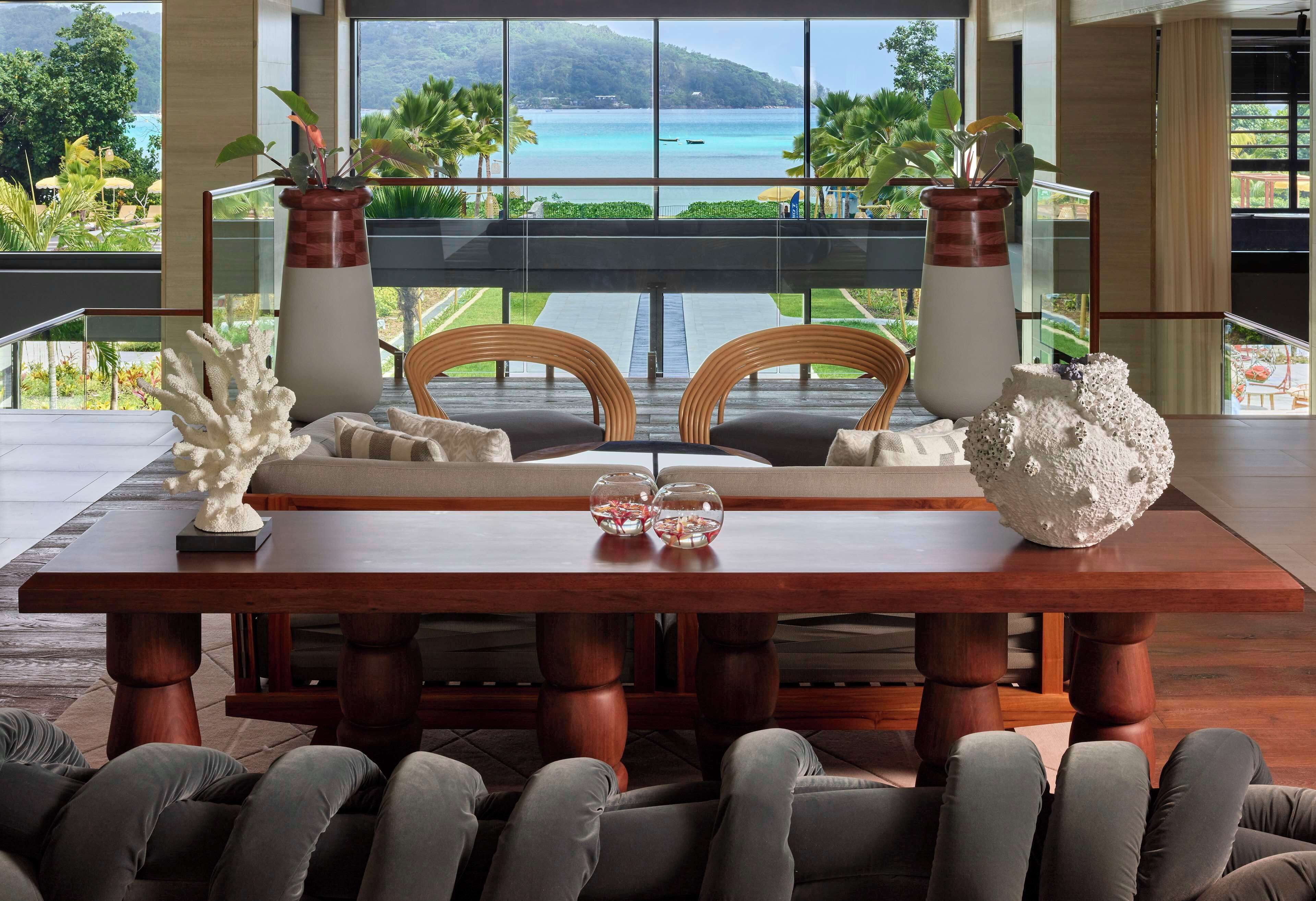 Un coin repas avec vue sur la mer, comprenant une table en bois, deux chaises et des objets décoratifs.