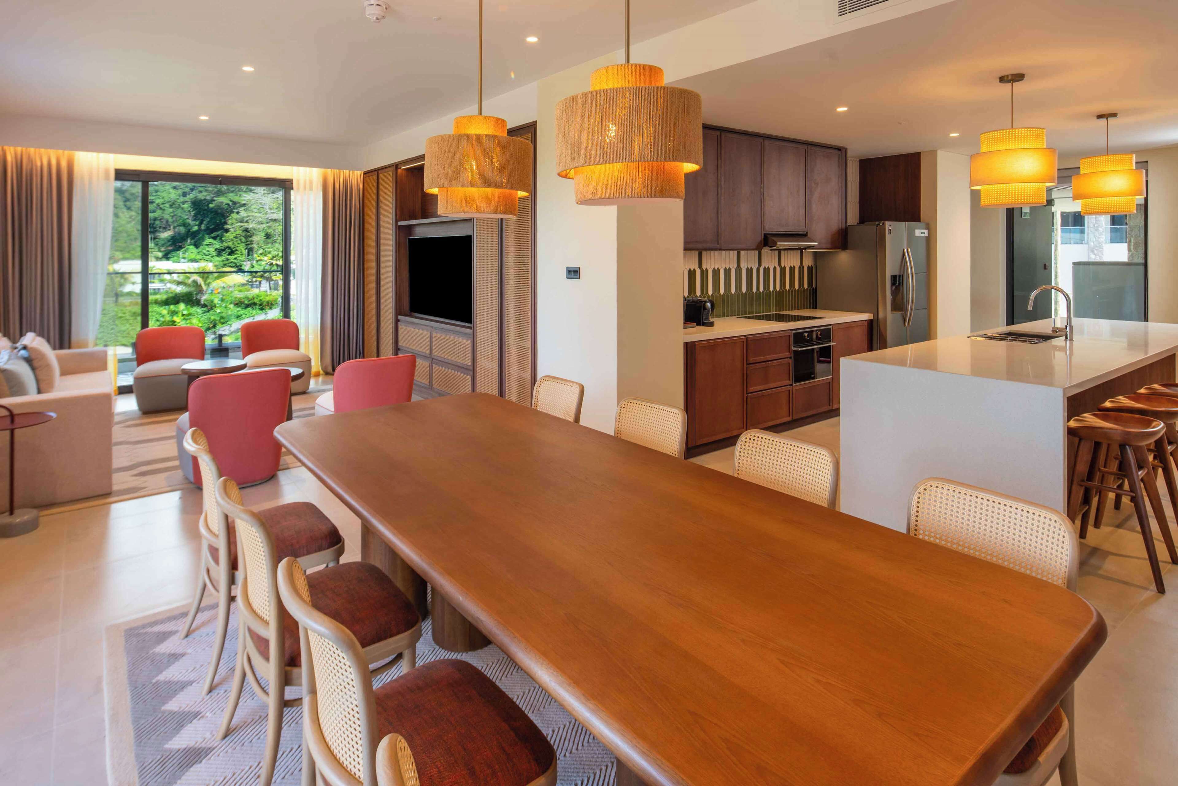 Una cocina moderna con una isla central, armarios de madera y electrodomésticos de acero inoxidable.