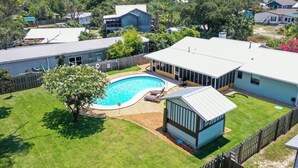 Una propiedad residencial con piscina, patio cercado y garaje independiente.