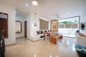 Relax in a serene living area with a sofa, dining table, and hammock, offering a peaceful atmosphere and a clear view of the outdoors.