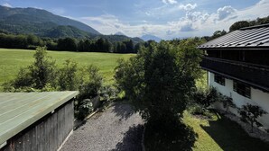 A view of a mountain landscape with a building featuring a sloped roof.
