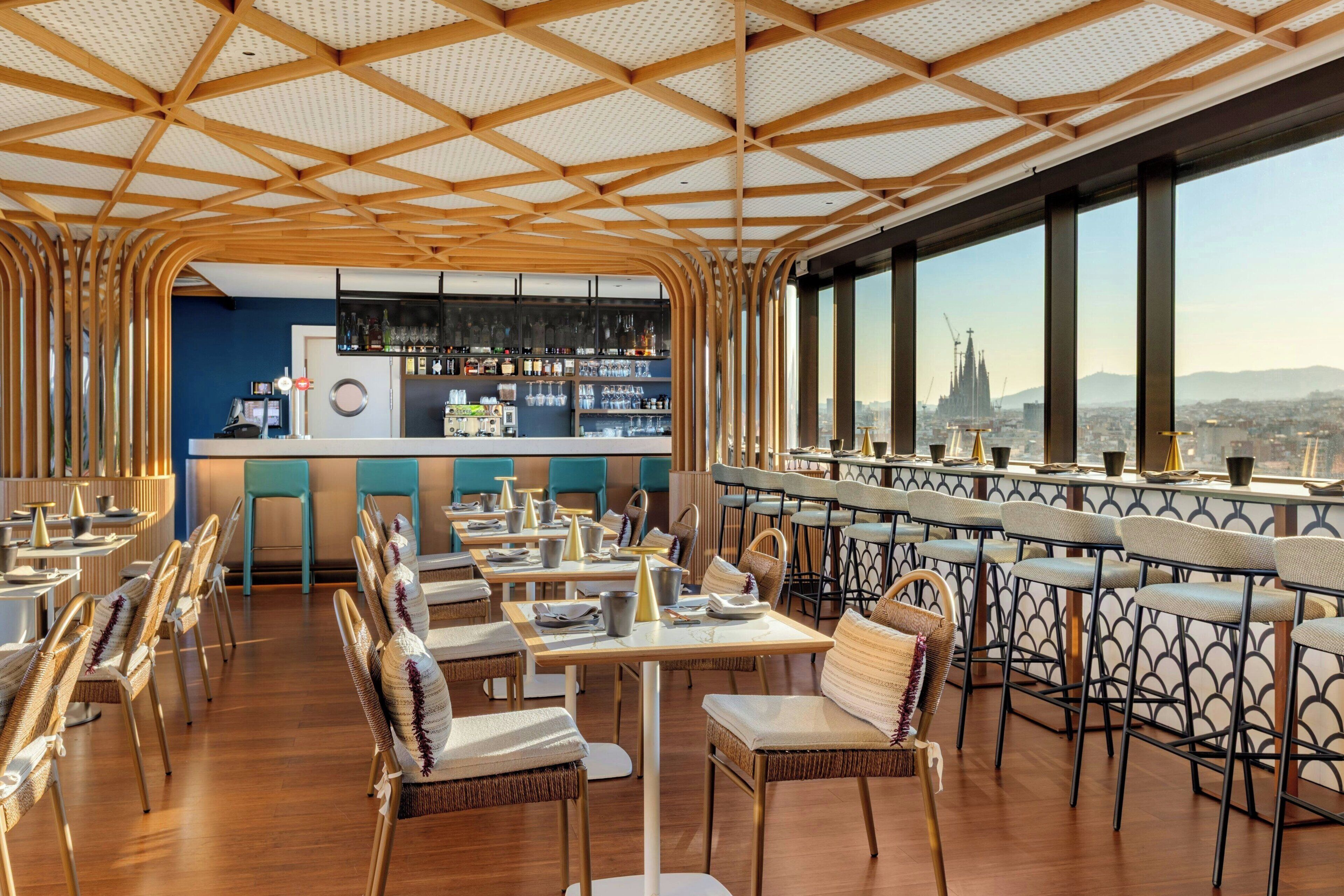 Ein Restaurant mit hoher Decke, Holzbalken und Blick auf die Stadt.