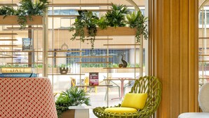 Un intérieur moderne avec un canapé, des fauteuils, une petite table et des plantes en pot.