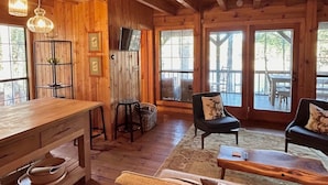 Ein rustikales Holzinterieur mit Essbereich, Bar und Sitzgelegenheiten an großen Fenstern.