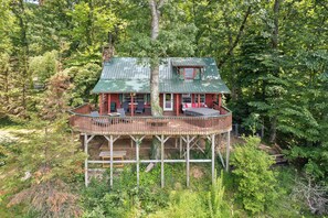 A cabin with a wooden deck, a covered porch, and a small window. - 4BD Rustic Log Cabin With Incredible Deck and View! (Gatlinburg)