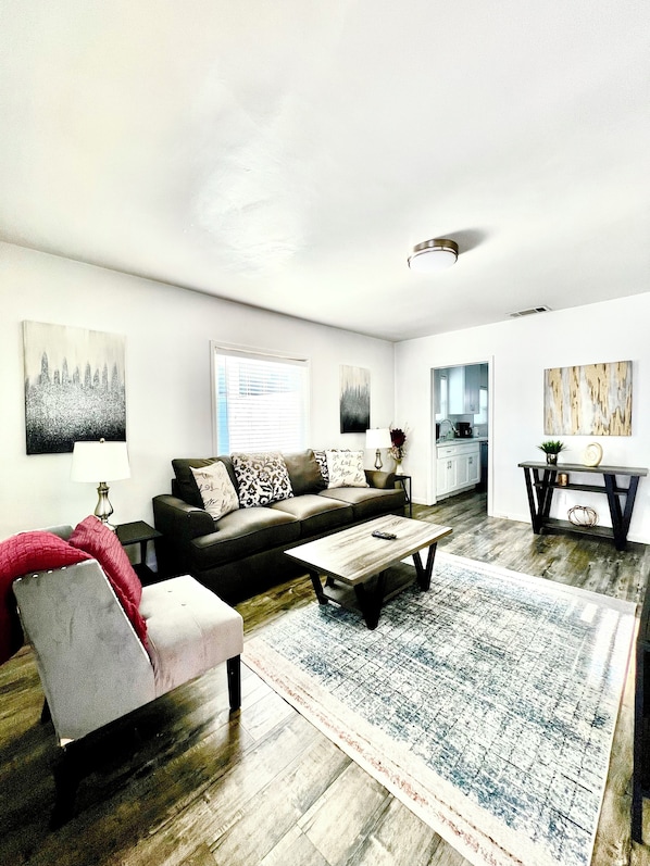 Relax in this stylish living room with a large sectional sofa, coffee table, and area rug.